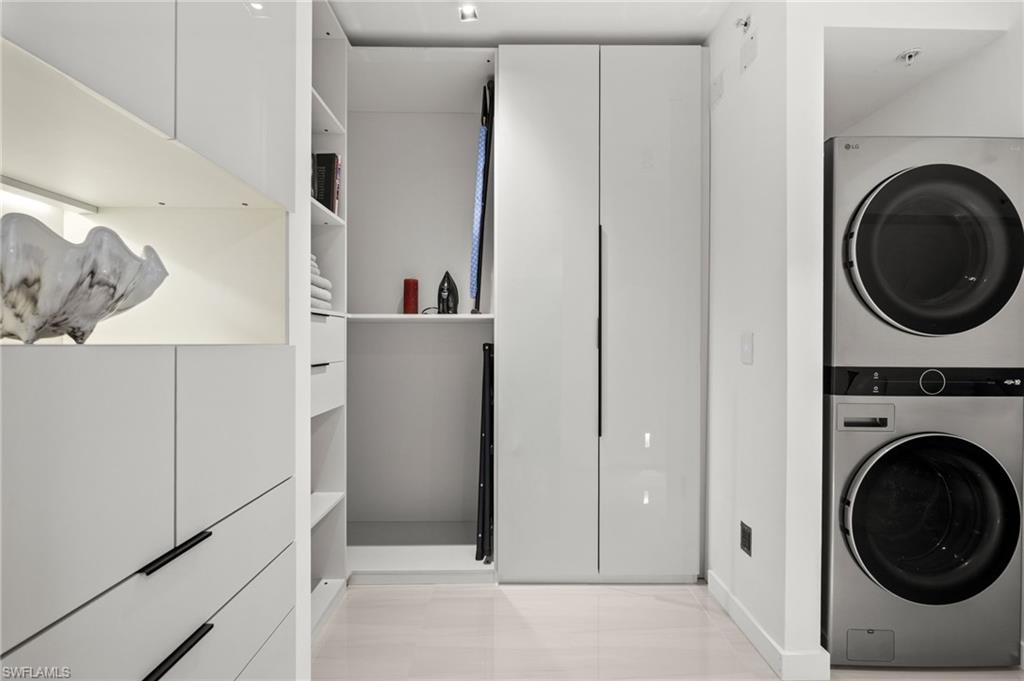 Integrated laundry area featuring a stacked washer and dryer