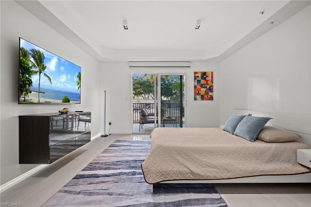 Bright interior space featuring a wall-mounted television, a contemporary floating cabinet, and light-toned flooring