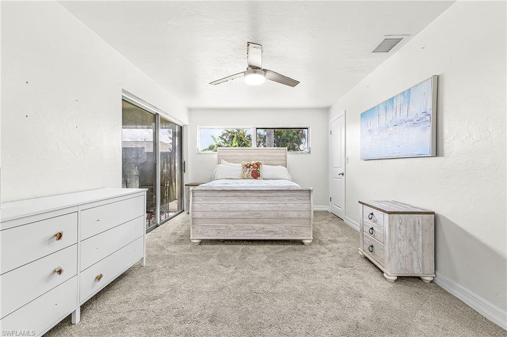 Primary Bedroom with slider to lanai, walk in closet and bath with walk in shower ....carpet with Terrazo floors beneath.