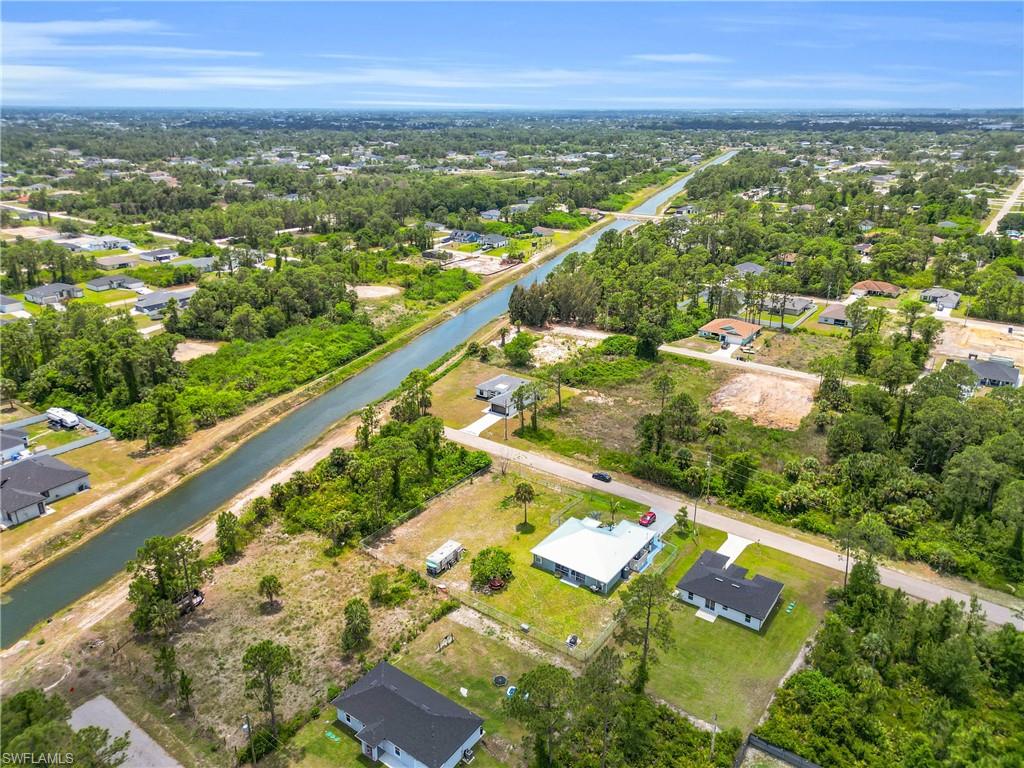Aerial perspective showcasing the surrounding neighborhood, a prominent canal, and verdant tree cover