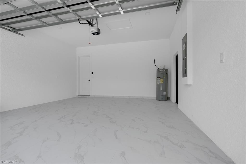 Spacious garage featuring light-toned flooring, white walls, and an automatic garage door opener