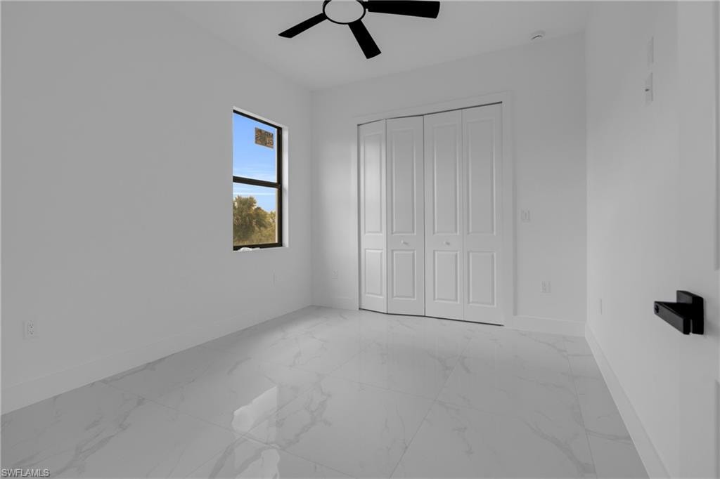 Bright interior space featuring white walls and marble-look tile flooring
