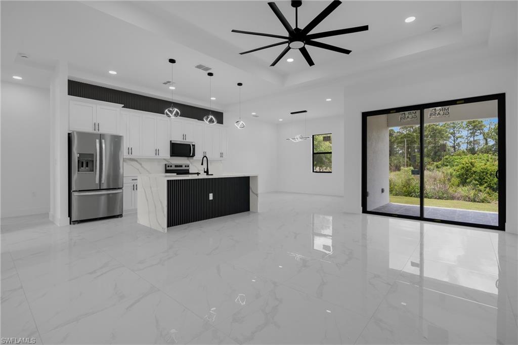 Open-concept kitchen and living area featuring polished tile flooring