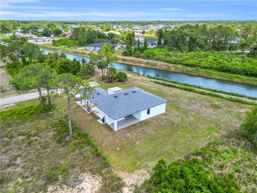 Aerial perspective of a single-story residence featuring a dark shingle roof and white exterior