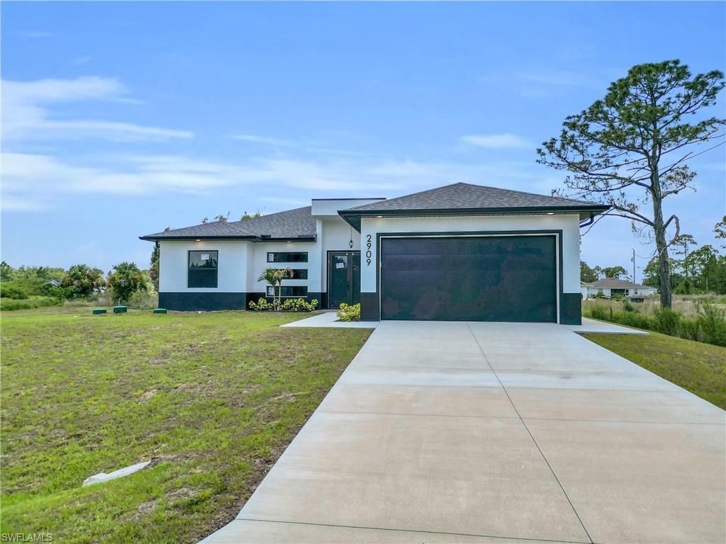 Contemporary exterior with a two-tone facade, attached garage, concrete driveway, and a covered entry