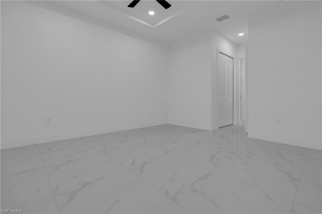 Interior room featuring large format tile flooring, white baseboards, a bi-fold closet door, a recessed ceiling fan, and recessed lighting