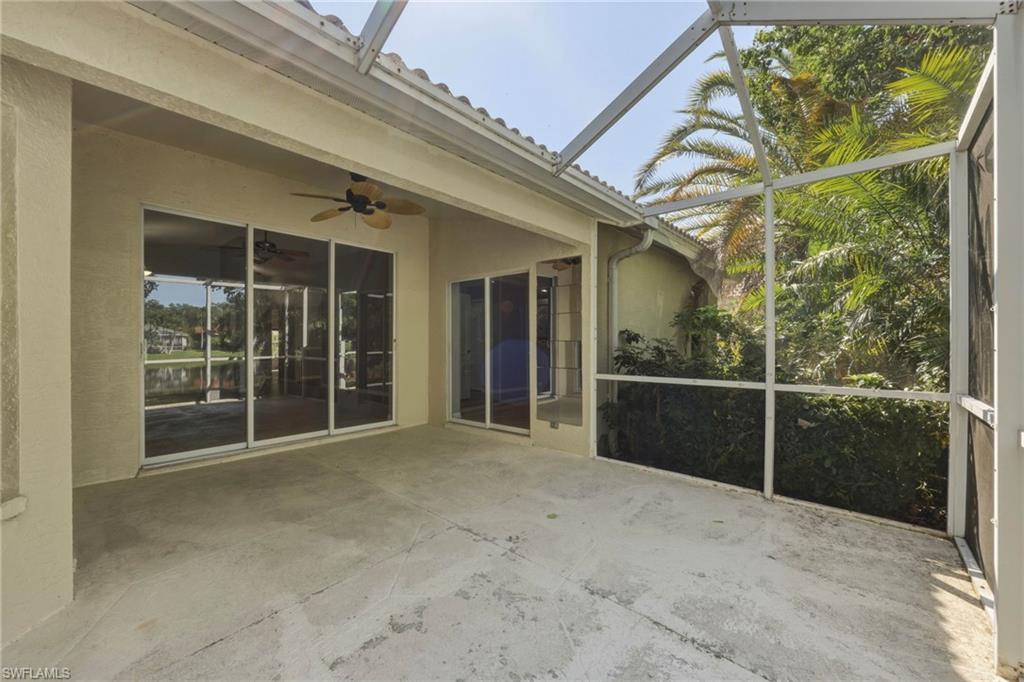 Screened concrete patio featuring multiple sliding glass doors and an exterior ceiling fan