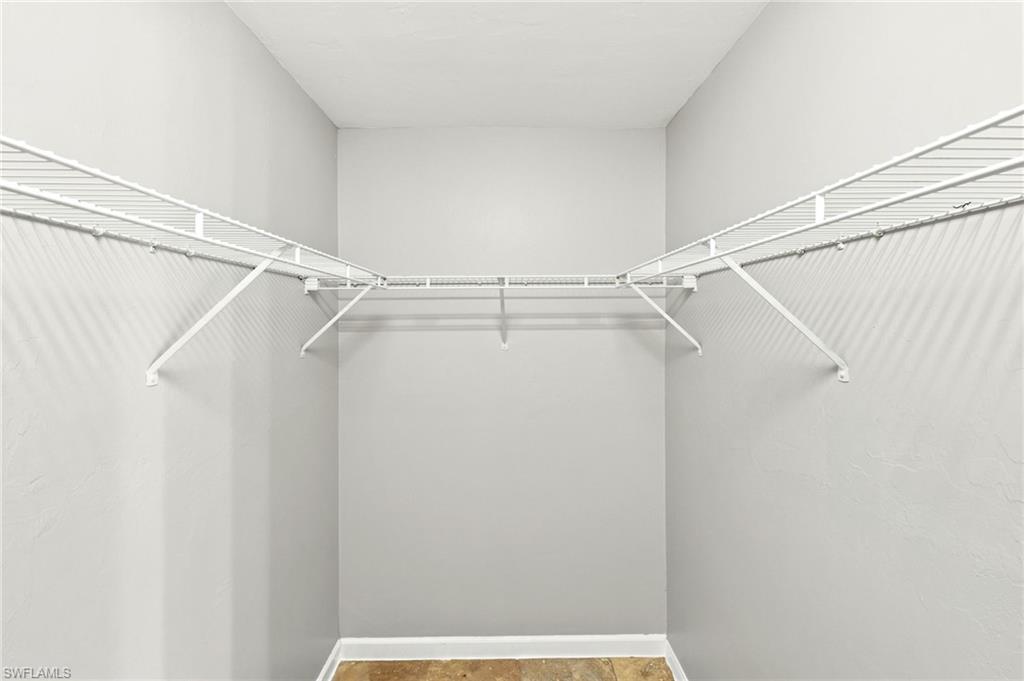 Walk-in closet featuring light gray painted walls and white wire shelving