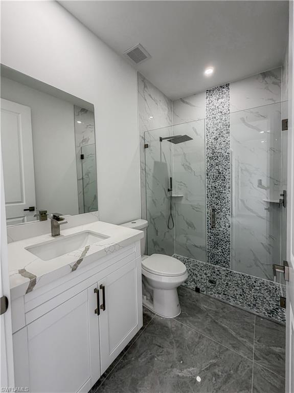 Bathroom featuring a glass-enclosed shower with wall-mounted fixtures
