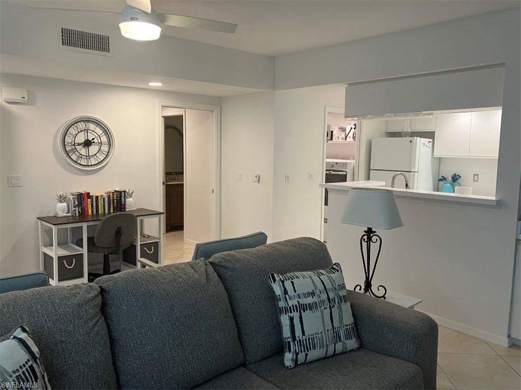 Living room with light tile patterned floors, ceiling fan, and recessed lighting