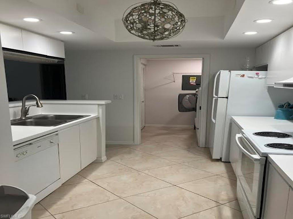 Kitchen featuring recessed lighting, light countertops, white appliances, white cabinets, and light tile patterned flooring