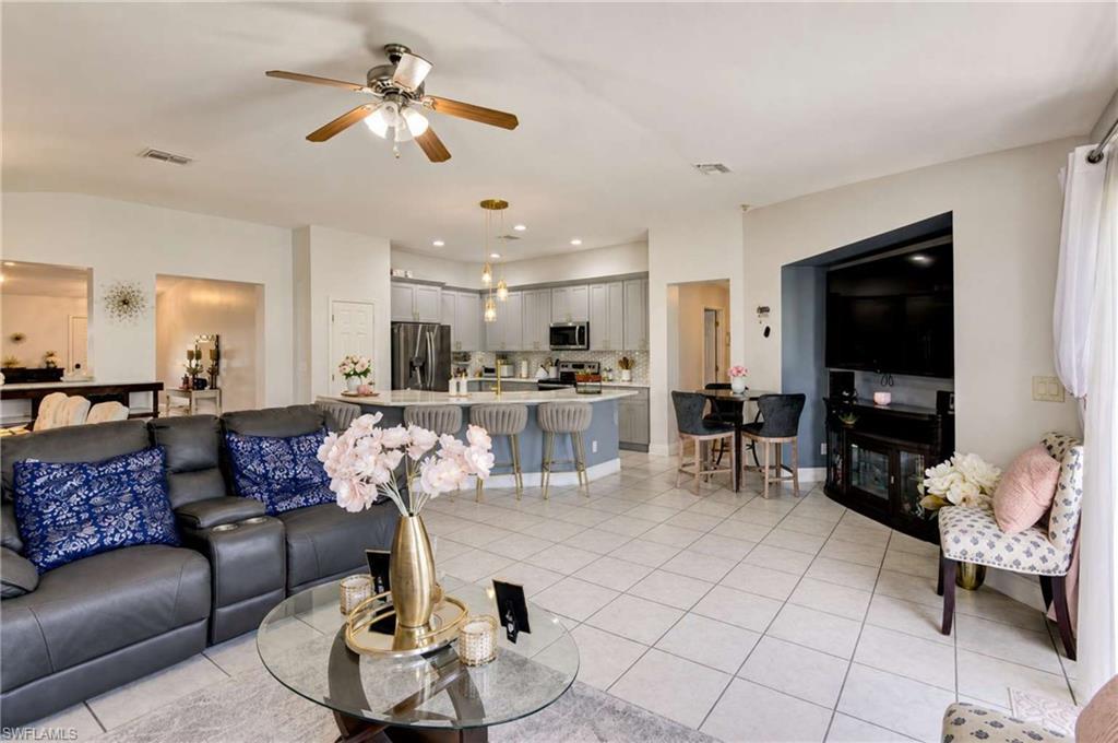 Open-concept living area with tile flooring, a ceiling fan, and recessed lighting