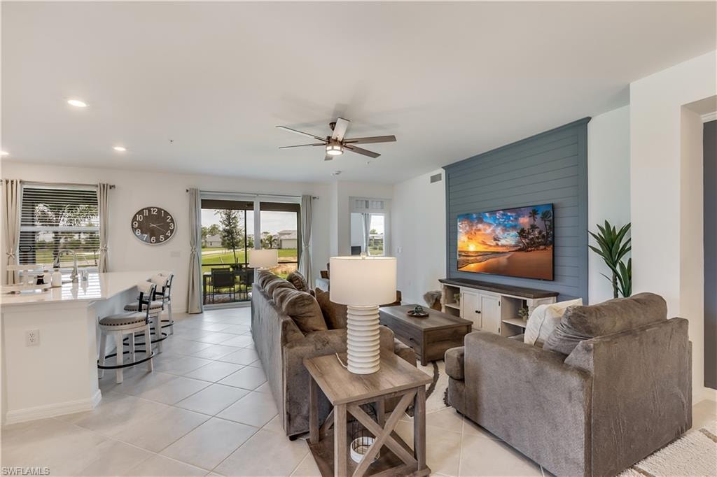 Living room featuring sink, ceiling fan, and light tile floors