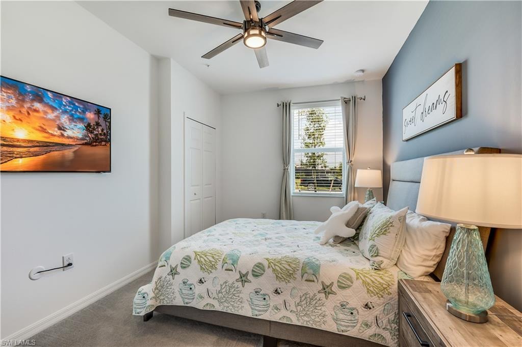 Carpeted bedroom with a closet and ceiling fan