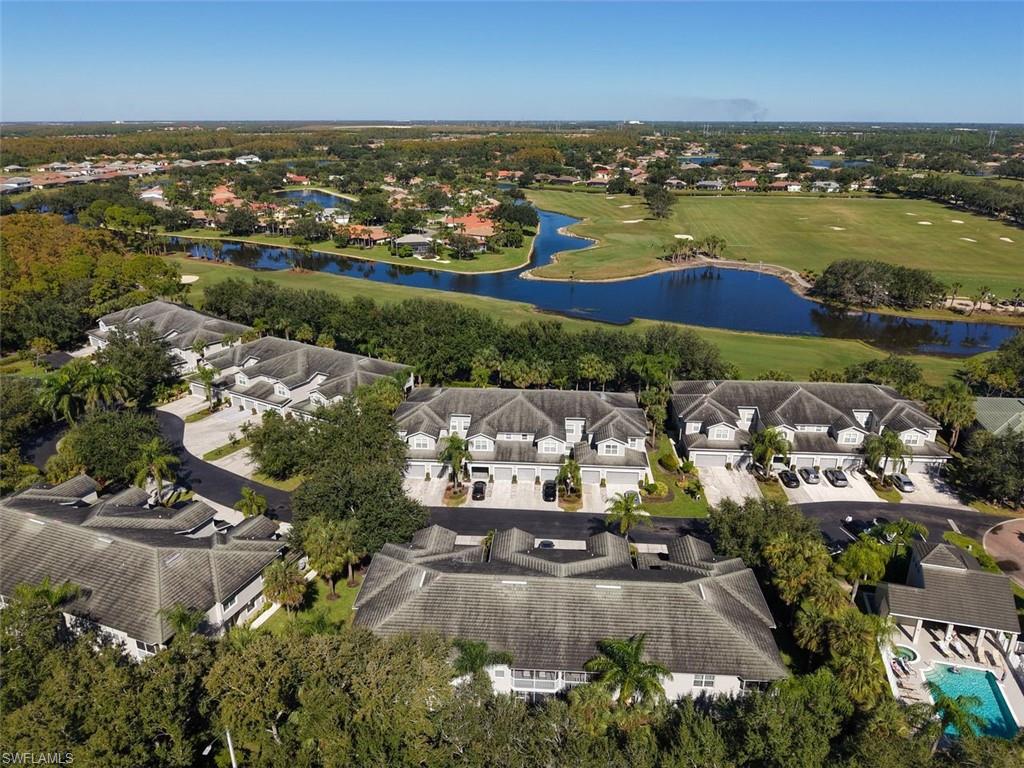Aerial perspective of suburban area with a nearby body of water and a golf course