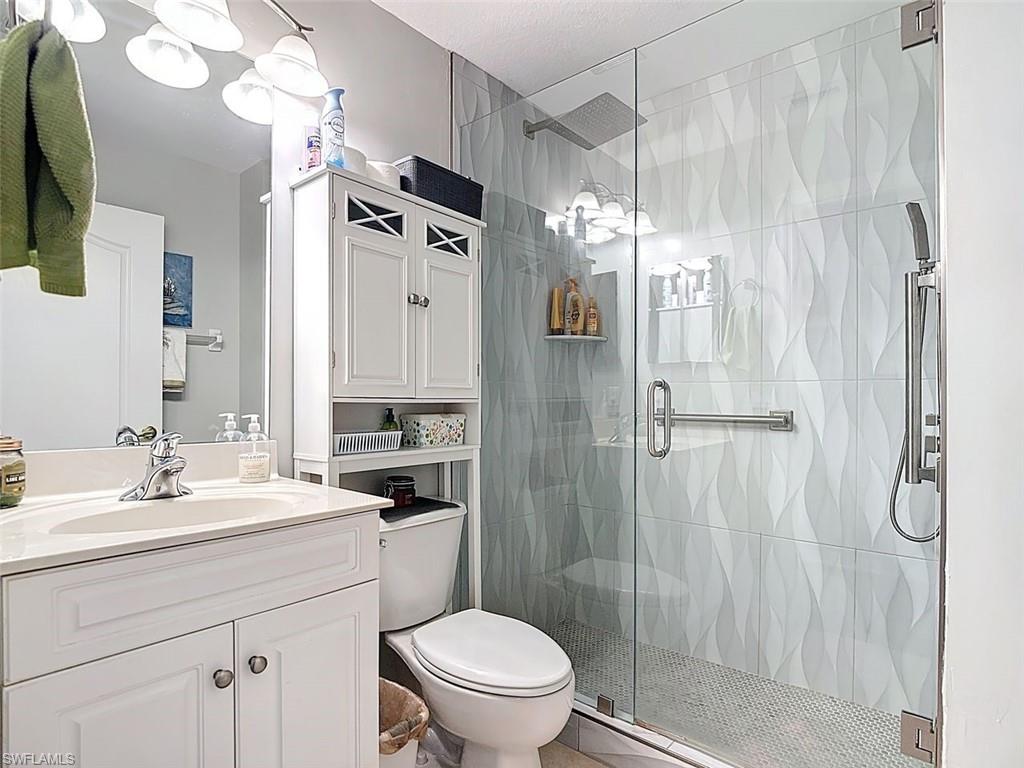 Full bathroom with vanity and a shower stall