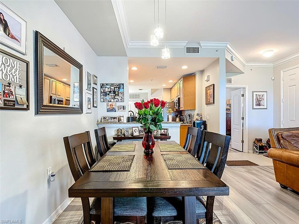 Dining room with crown molding and light wood finished floors
