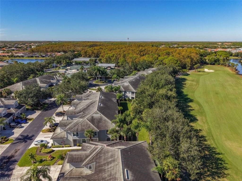 Aerial perspective of suburban area with a large body of water and a golf club