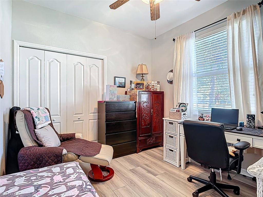 Home office with light wood finished floors and a ceiling fan