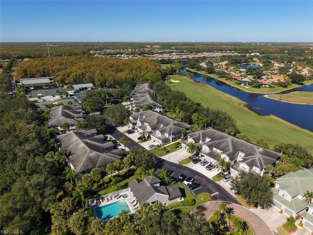 Aerial perspective of suburban area with a nearby body of water and a golf club