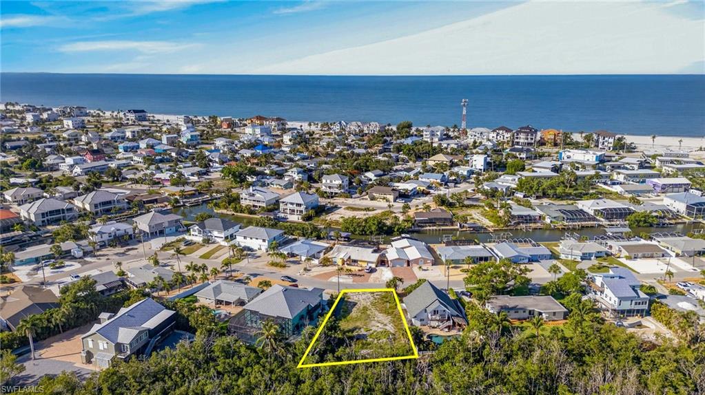 Cleared building lot outlined in yellow, surrounded by mature trees - Virtually Edited Image