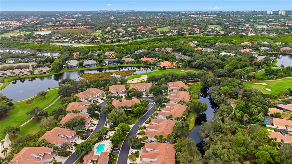 Aerial view of property's location with nearby suburban area, a nearby body of water, and a golf course
