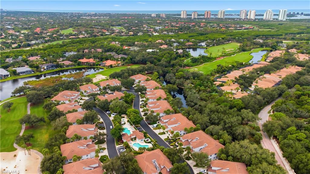 Aerial view of residential area featuring a nearby body of water and a golf course