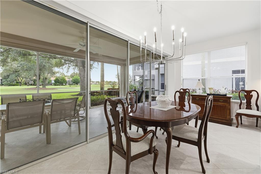 Dining space with light tile patterned flooring, a chandelier, ceiling fan, and a sunroom
