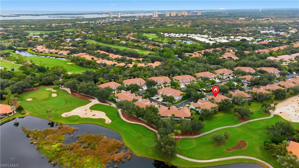 Aerial perspective of suburban area featuring a nearby body of water and a golf club