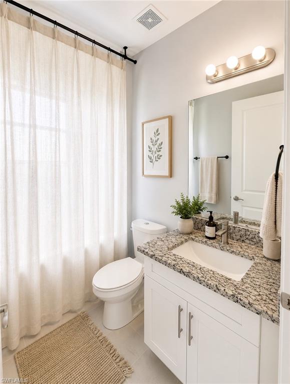 Second Bathroom featuring a white vanity with brushed nickel hardware, granite-style countertop, and an undermount sink