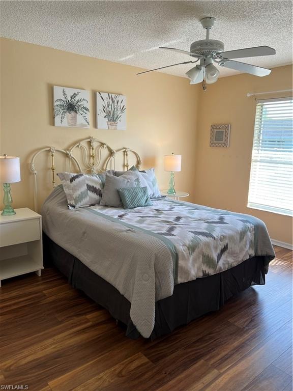Spacious room featuring wood-finish flooring, a multi-blade ceiling fan with integrated lighting, and a large window with horizontal blinds
