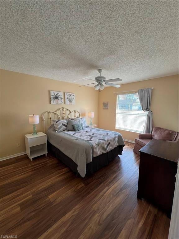 Interior room featuring wood-finish flooring, a ceiling fan with integrated lighting, and a window with blinds and drapes