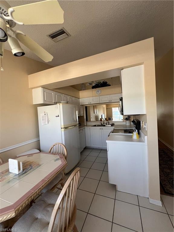 Kitchen featuring white cabinetry, a built-in electric range, and a dual-basin sink with a window above