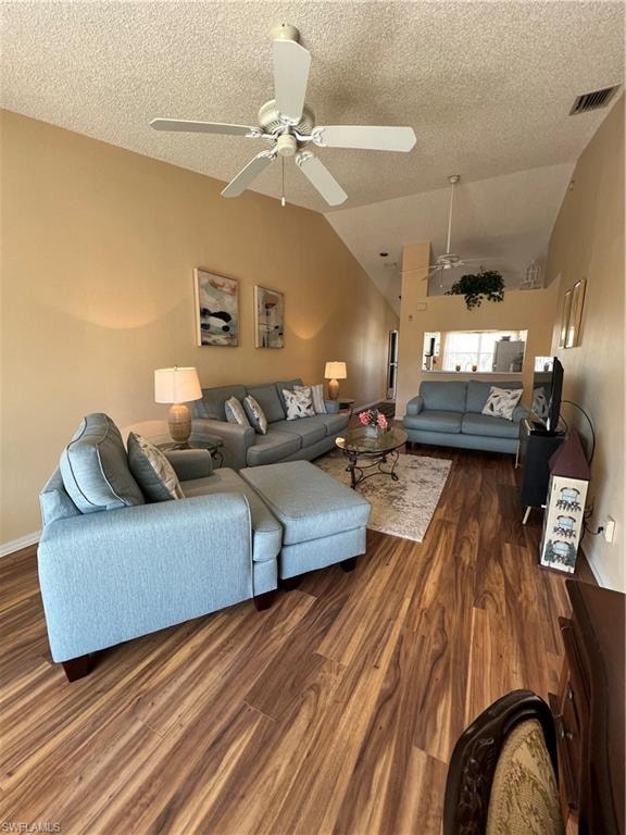 Open concept living area featuring vaulted ceilings, wood-finish flooring, and ceiling fans