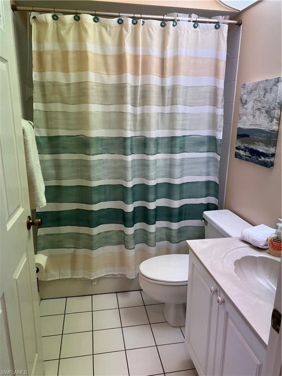 Bathroom with white square floor tiles, a white vanity with an integrated sink, and a toilet