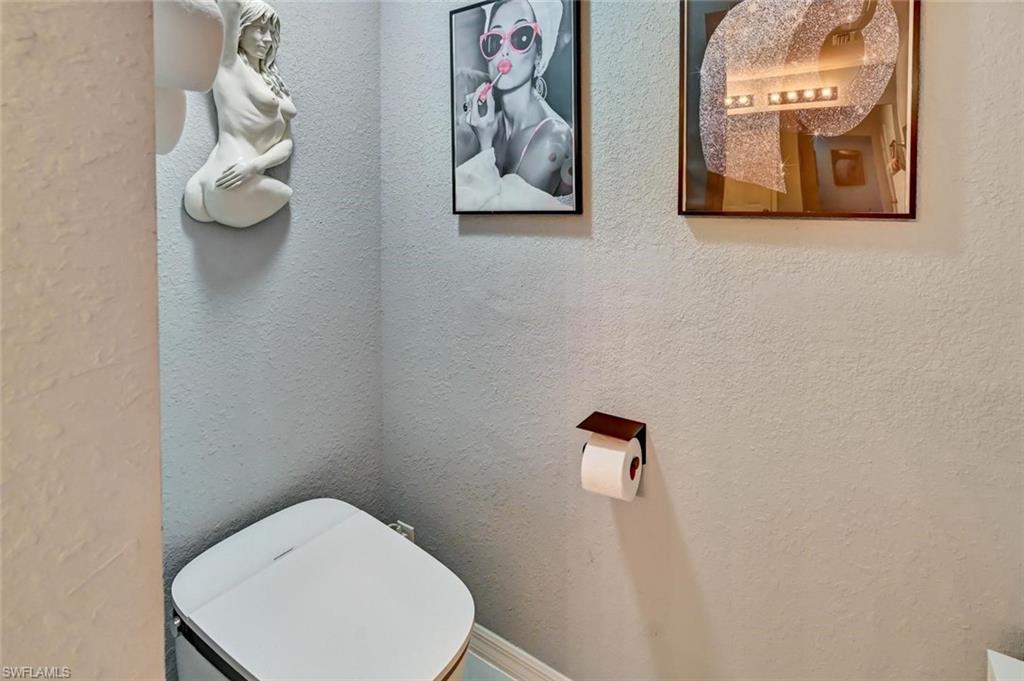 Modern toilet with a white lid and light gray textured walls