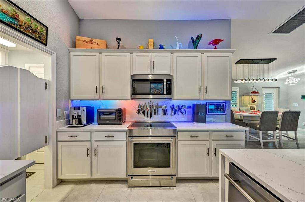 Modern kitchen featuring white shaker cabinetry, stainless steel appliances, and a built-in microwave