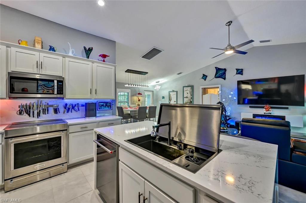 Modern kitchen featuring white cabinetry, a stainless steel appliance suite, and quartz countertops