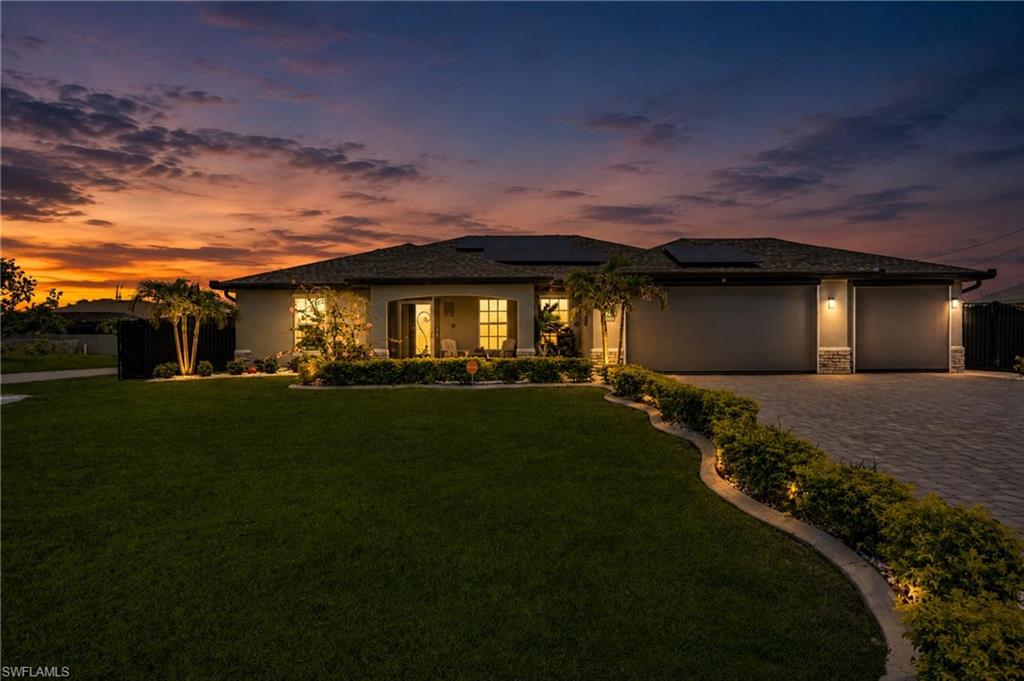Contemporary exterior with a paver driveway, multiple garage doors, and a manicured lawn