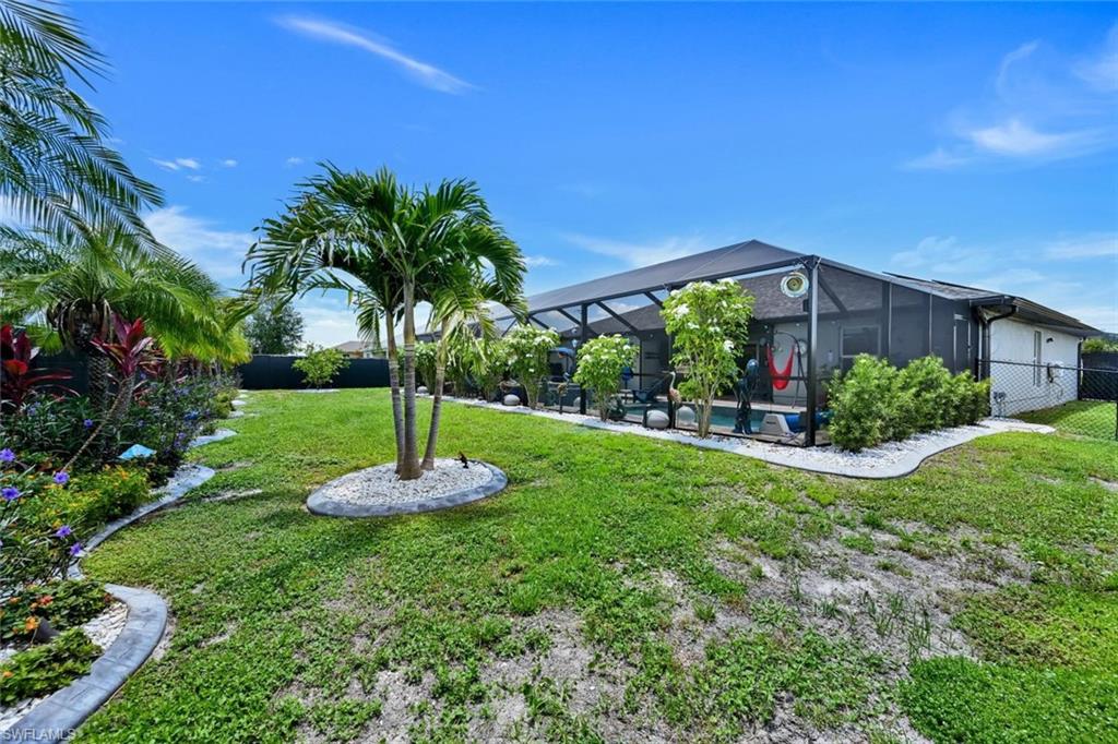 Expansive green lawn with mature palm trees and landscaped borders