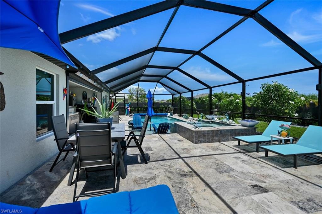 Screened lanai featuring a swimming pool, integrated spa, and expansive paver patio
