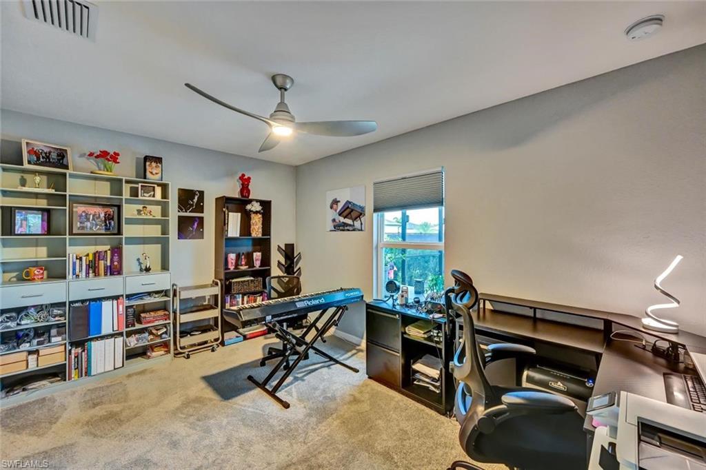 Spacious room featuring carpeting, a ceiling fan, and a window with blinds