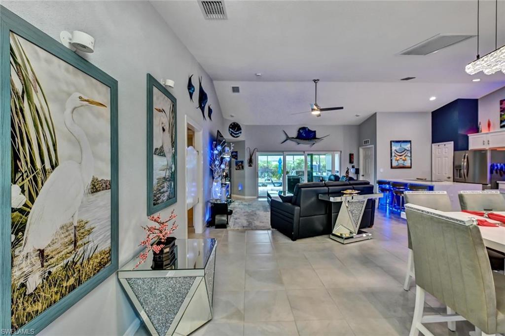 Open-concept living area featuring light gray wall tones, ceiling fan, recessed lighting, and tile flooring