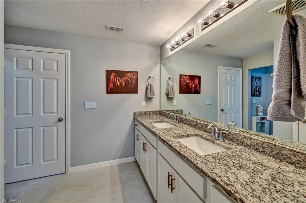 Dual vanity featuring granite countertops and undermount sinks