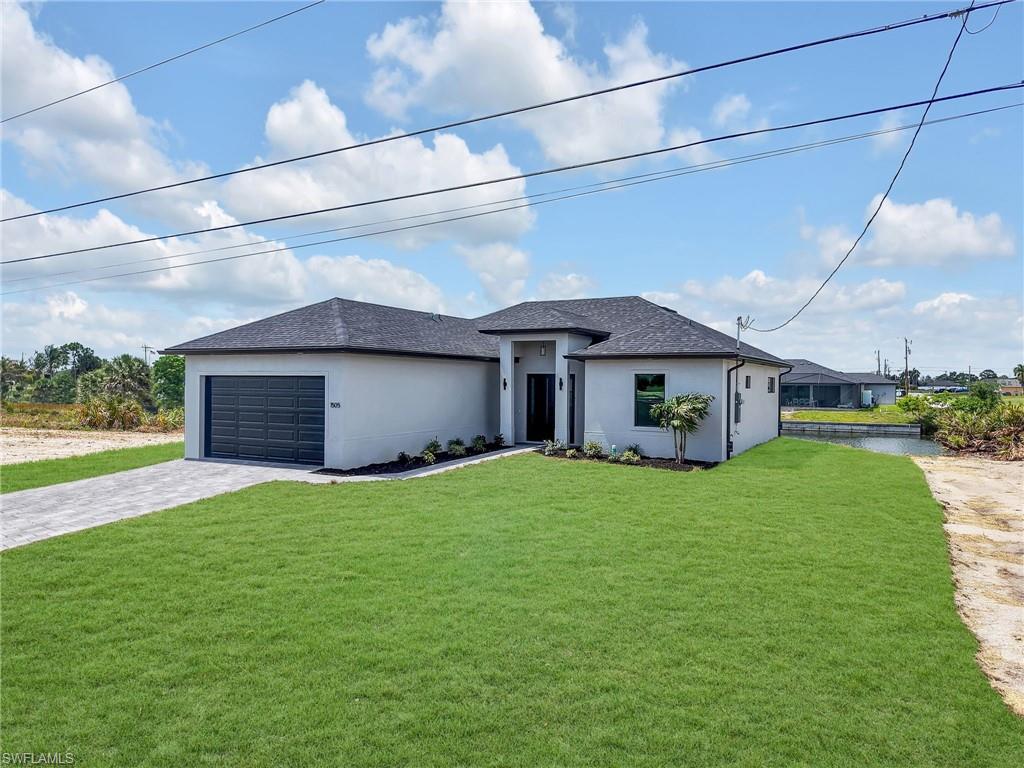 Contemporary single-story residence featuring a dark gray shingle roof, a two-car garage with a paneled door, and a paver driveway