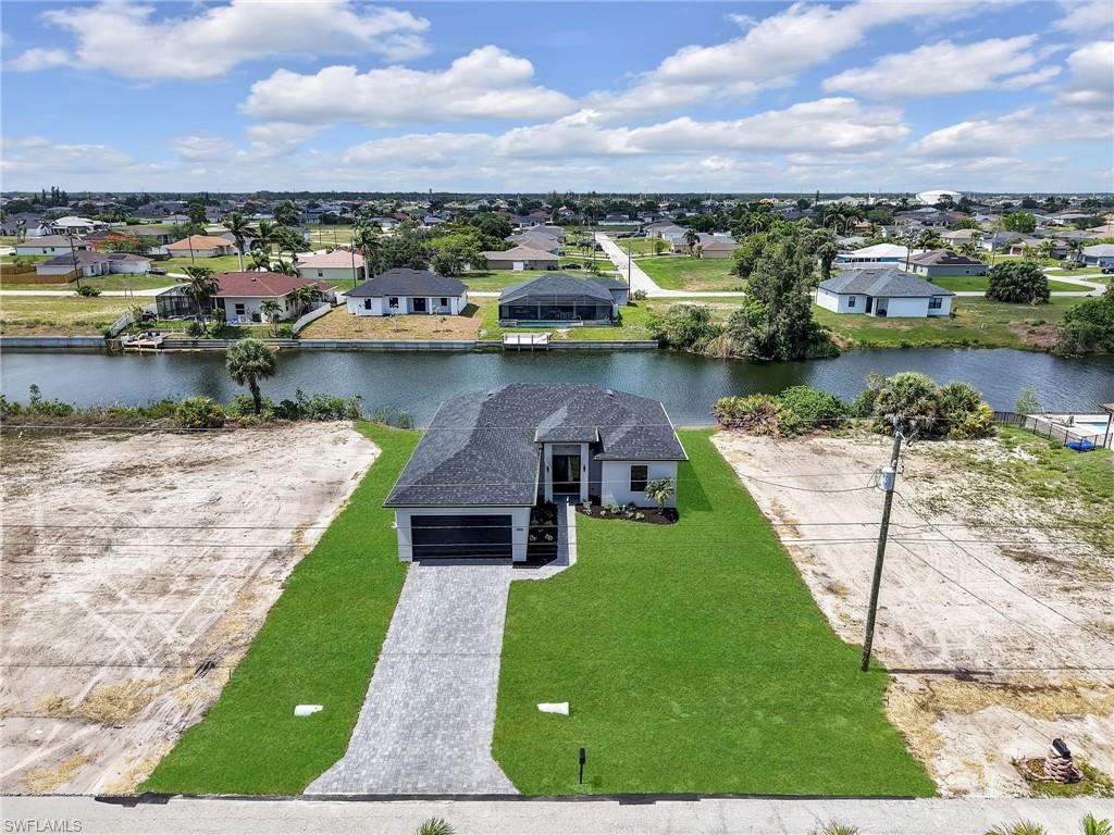 Contemporary single-story residence featuring a dark shingle roof, a paver driveway, and a two-car garage