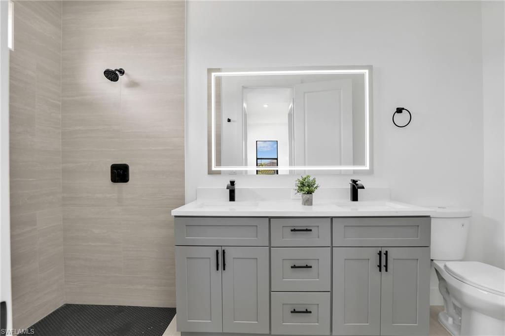Dual vanity with a light gray cabinet base, white countertop, and matte black fixtures