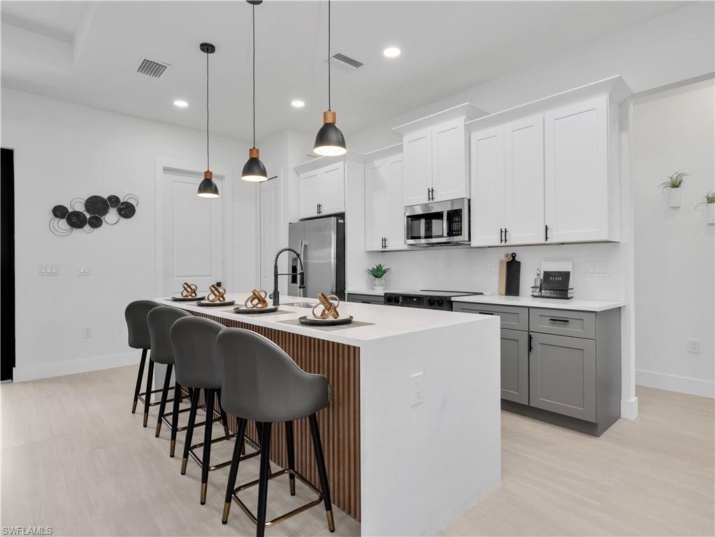 Modern kitchen featuring light wood-finish flooring and a central island with a slatted wood-finish accent panel