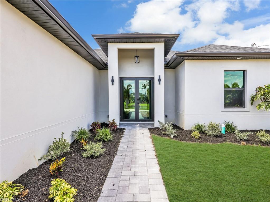 Modern stucco exterior with dark trim and a prominent covered entryway