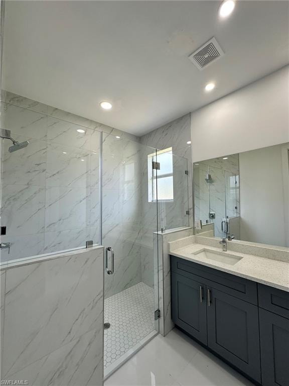 Bathroom featuring tile floors, an enclosed shower, and vanity